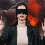 Une femme les yeux bandé ne veut pas regarder une explosion