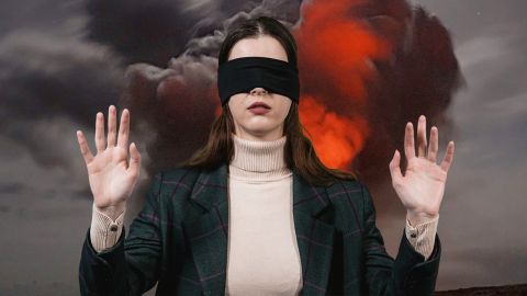 Une femme les yeux bandé ne veut pas regarder une explosion