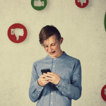 Un adolescent au milieu de pouces en l'air ou baissés