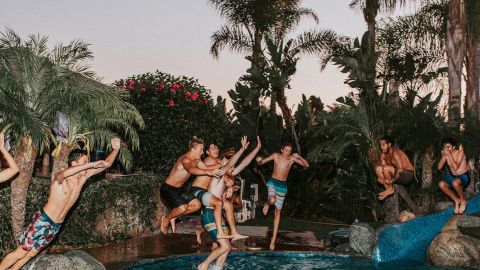Jeunes très heureux sautant dans une piscine