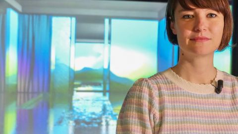 Sabrina Ratte devant son oeuvre d'art en vidéo synthétisée