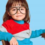 Enfant de 4 ans à lunettes et smartphone rouge