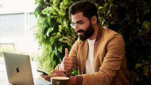 Homme devant son pc avec un pouce levé