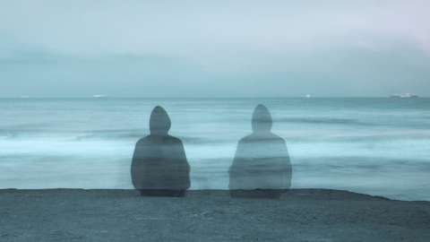 Deux silhouettes assises face à la mer