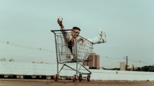Homme dans un caddie de supermarché