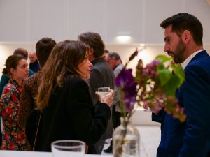 deux personnes discutent debout avec un verre