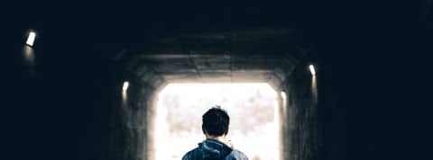 La santé mentale des Américains a souffert pendant la crise, et de nouvelles recherches montrent que les dommages ne se sont pas limités aux adultes. Jeune homme de dos devant un tunnel