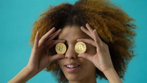 Femme avec un bitcoins devant chaque oeil