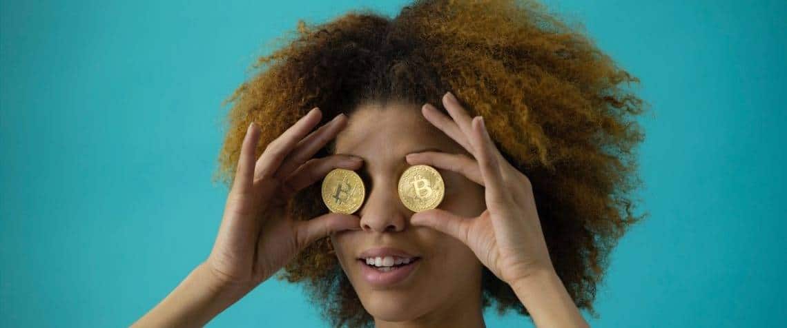 Si le Bitcoin reste le roi incontesté des cryptos depuis son lancement en 2009, de nombreux altcoins l'ont surperformé en 2021. - L'ADN Femme avec un bitcoins devant chaque oeil
