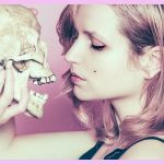 Femme tenant joliment une tête de mort devant son visage