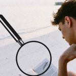 Un homme en train de lire sur une plage