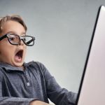 Choqué et de surprise garçon sur internet avec un ordinateur portable