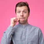 Jeune homme montrant un signe de fermer la bouche et le silence