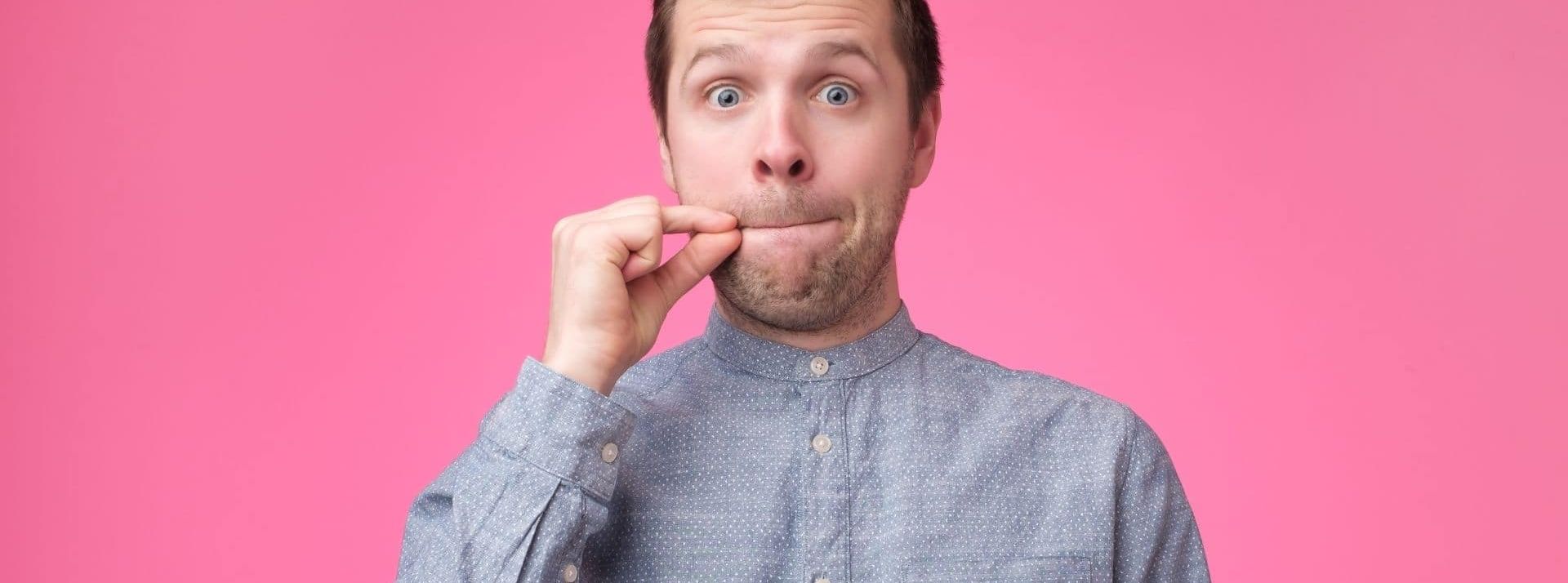 Jeune homme montrant un signe de fermer la bouche et le silence