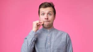 Jeune homme montrant un signe de fermer la bouche et le silence