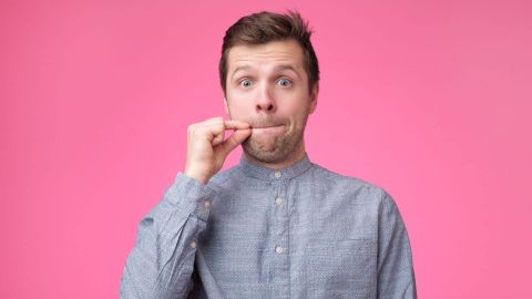 Jeune homme montrant un signe de fermer la bouche et le silence