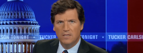 tucker un présentateur télé qui lance un regard sournois.
