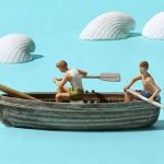 Une figurine de bateau sur un fond bleu avec des coquillages blancs