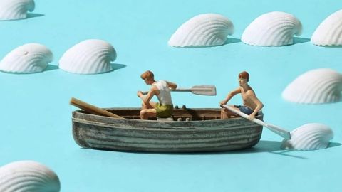 Passion miniature Une figurine de bateau sur un fond bleu avec des coquillages blancs