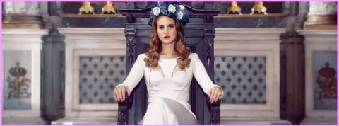 La chanteuse Lana del Rey en robe blanche assise sur un trone dans une église avec une couronne de fleurs sur la tête