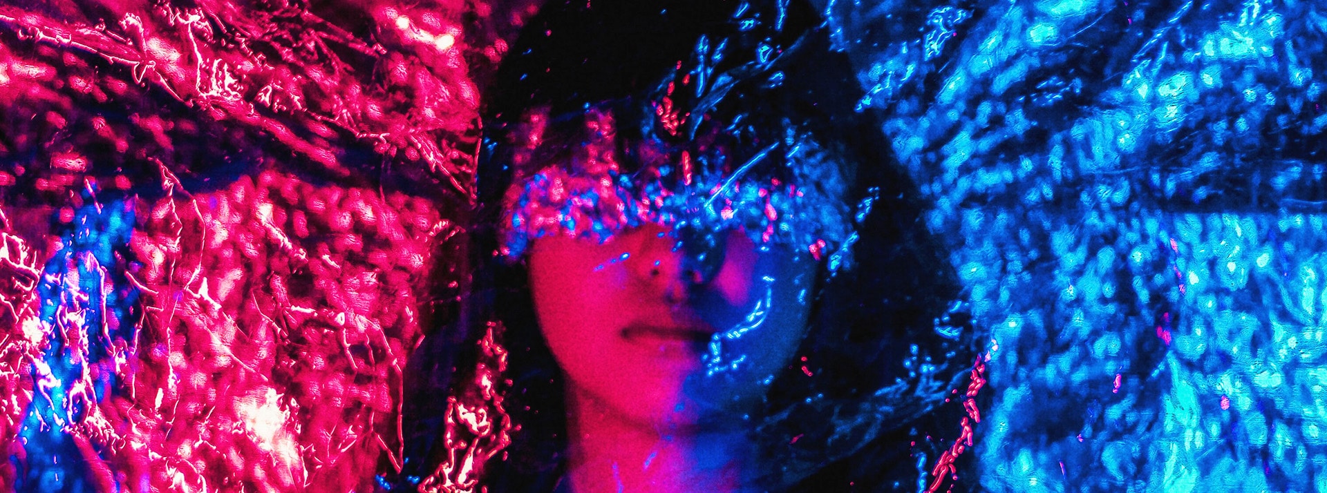 Femme avec film sur les yeux dans des couleurs de nuit bleu et rouge