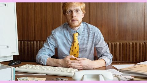 Un homme en chemise assis à son bureau