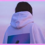Une femme de dos en pull à capuche blanc