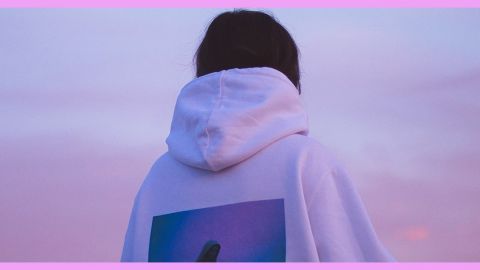 Une femme de dos en pull à capuche blanc