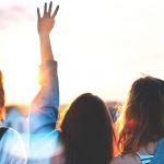 Jeunes femmes de dos, les brad en l'air, tournées vers l'avenir tournées