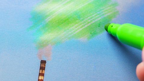 Homme peignant la pollution verte d’une cheminée