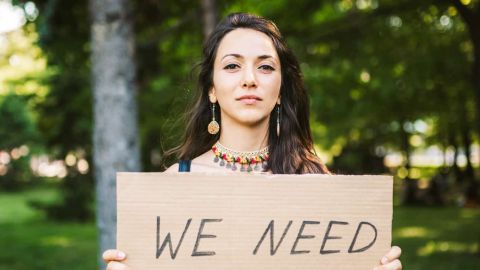 Jeune femme tenant une pancarte  - I need - 