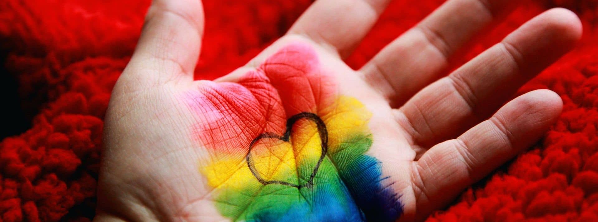Une enquête du Pew Research Center révèle qu’environ 5% des Américains âgés de 18 à 29 ans s’identifient comme transgenres ou non binaires - L'ADN Main avec un drapeau LGBTQ au centre
