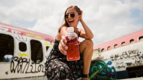 Jeune femme tenant une bouteille de Mogu Mogu dans ses mains