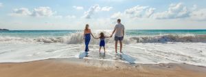 Famille sur une plage, face à la mer