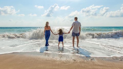 Famille sur une plage, face à la mer