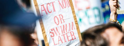 TotalEnergies partenaire du Qatar pour développer la pire bombe climatique du monde au monde Pancarte manifestation : Act Now or Swimm Later