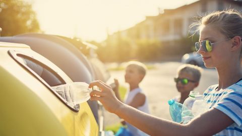 Kids putting garbage into plastic containers of different types