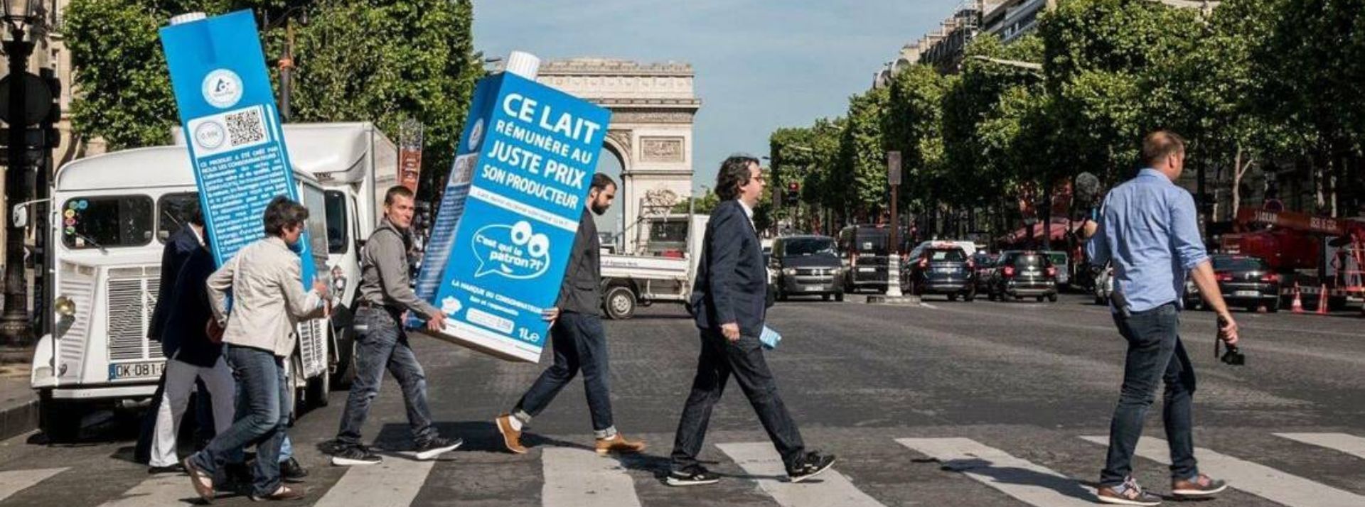 Nicolas Chabanne traversant les Champs Elysées suivi d'une bouteille de lait "c'est qui le patron"