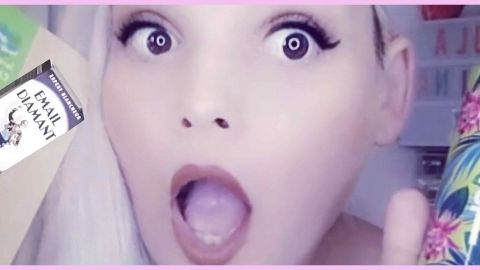 Une femme blonde la bouche ouverte tenant des produits de beauté