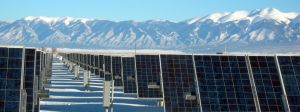 Panneaux solaires au pied de massifs montagneux enneigés