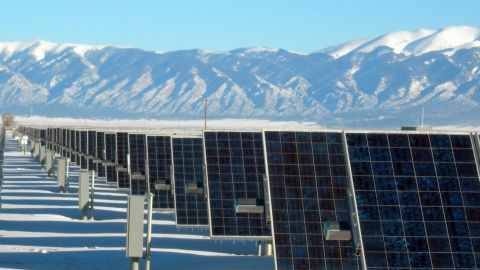 Panneaux solaires au pied de massifs montagneux enneigés