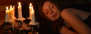 Visage d'une femme endormie éclairée par des bougies