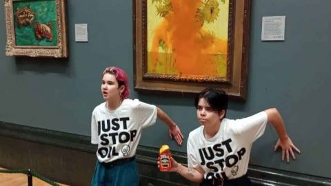 Militant du mouvement Just For Oil devant le tableau  - Les tournesols -  de Van Gogh