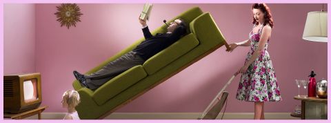 Bienvenue dans le monde des maris inutiles Un homme allongé sur un canapé et sa femme qui passe l'aspirateur