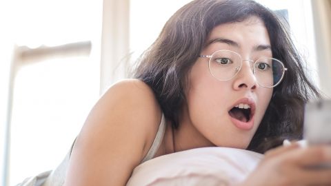 Une jeune femme panique devant son smartphone