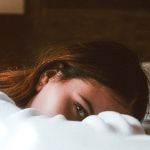 Femme fatiguée allongée sur le bord de son lit