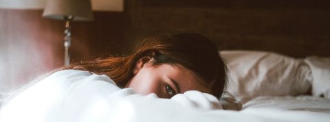 Retour de flemme Femme fatiguée allongée sur le bord de son lit