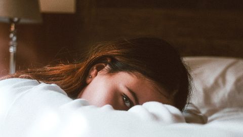 Femme fatiguée allongée sur le bord de son lit
