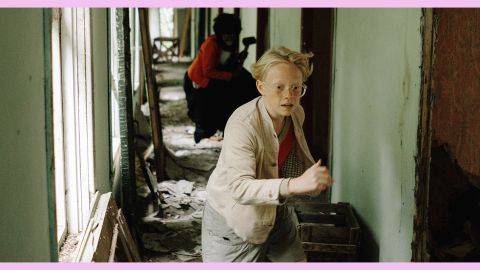 Un enfant blond qui court dans un couloir vert