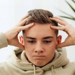 jeune homme déprimé, se prenant la tête